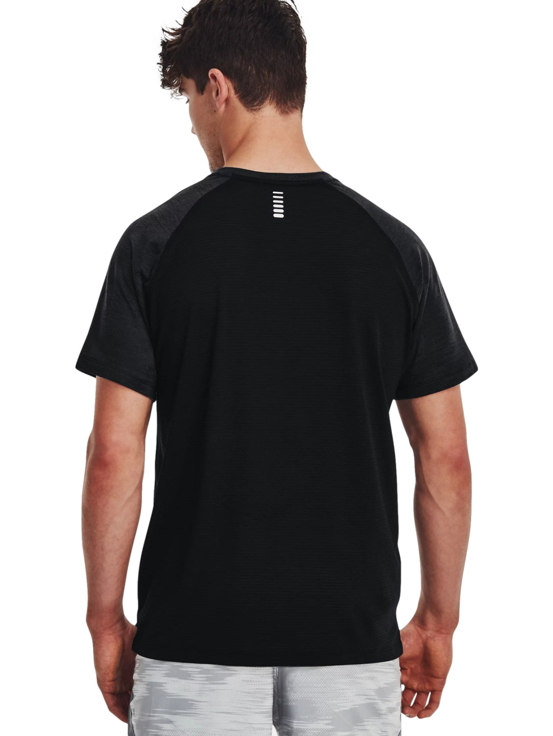 Hombre vistiendo una camiseta deportiva de manga corta color negro de la marca Under Armour.