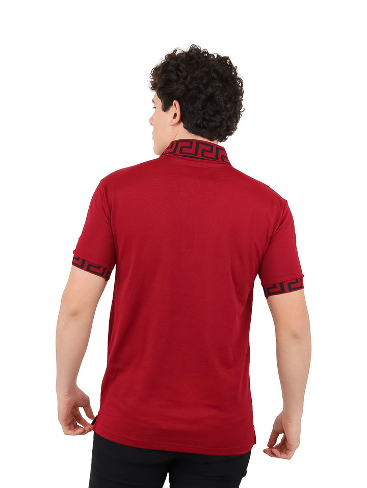 Hombre vistiendo playera polo color burgundy con detalles negros en el cuello y los bordes de las mangas.