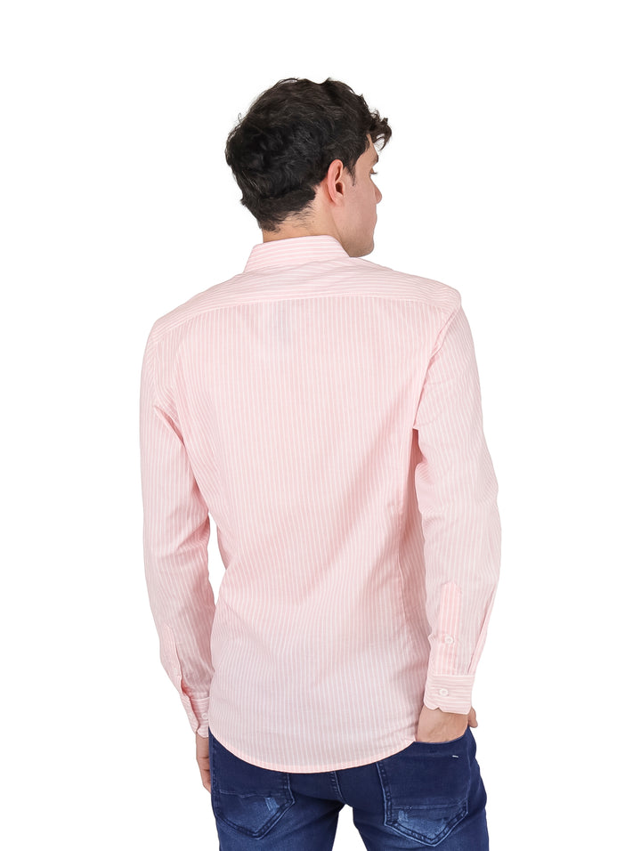 Hombre vistiendo una camisa de manga larga color rosa con rayas finas y pantalones azules.
