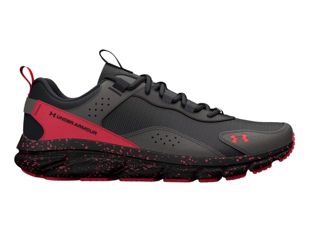 Tenis deportivos Under Armour en color gris con detalles y suela moteada en color rojo.