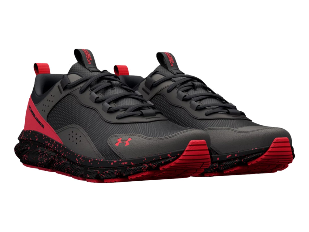 Tenis deportivos Under Armour en color gris con detalles y suela moteada en color rojo.