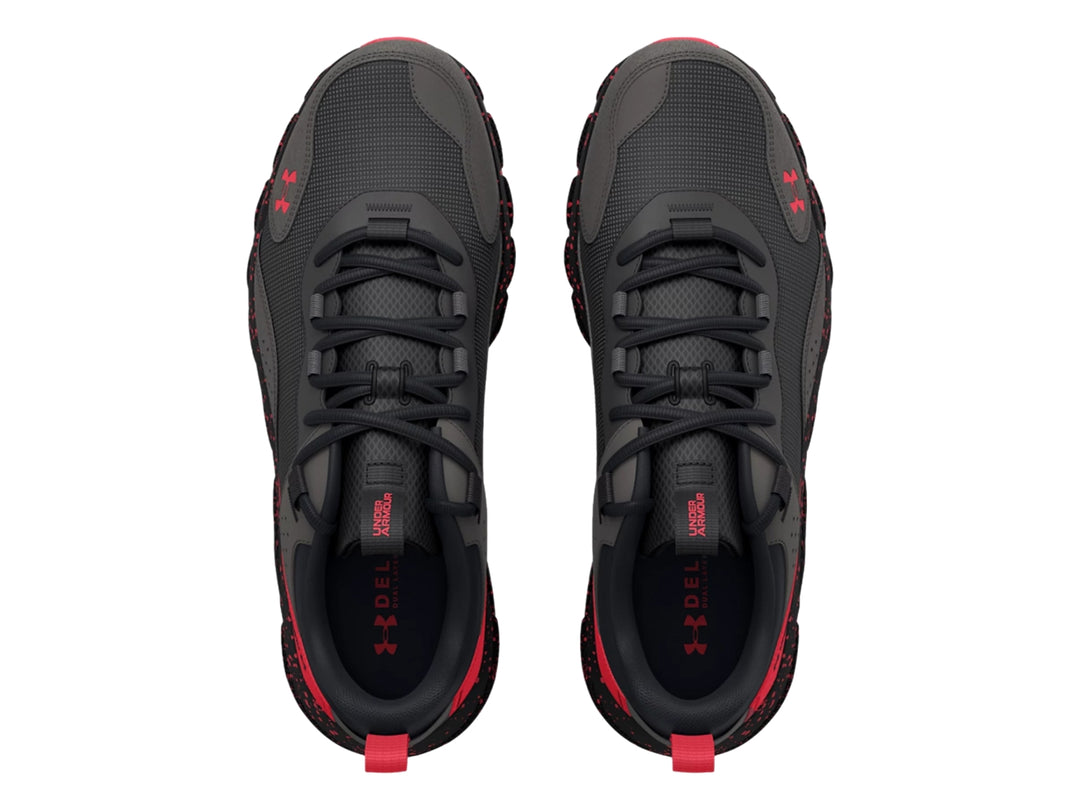 Tenis deportivos Under Armour en color gris con detalles y suela moteada en color rojo.