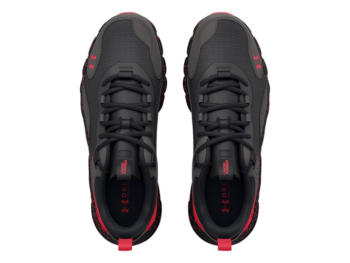 Tenis deportivos Under Armour en color gris con detalles y suela moteada en color rojo.