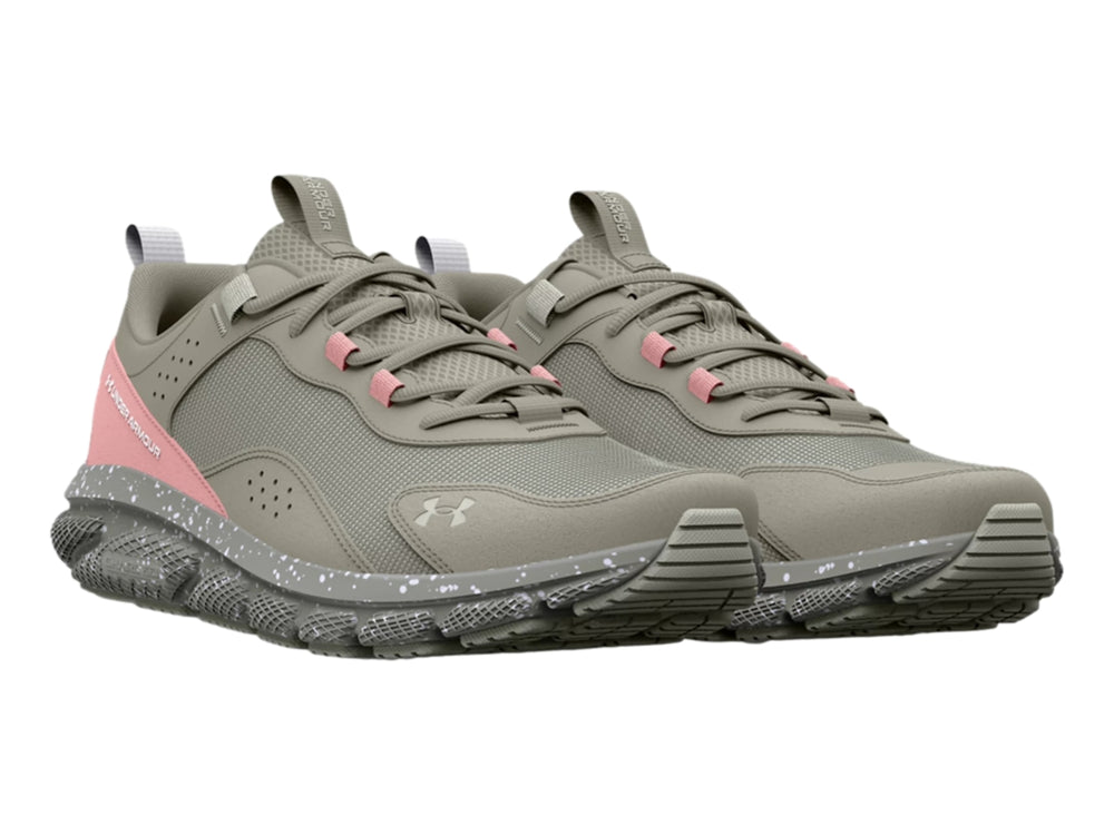 Tenis deportivos Under Armour en color gris con detalles en rosa y suela blanca moteada.