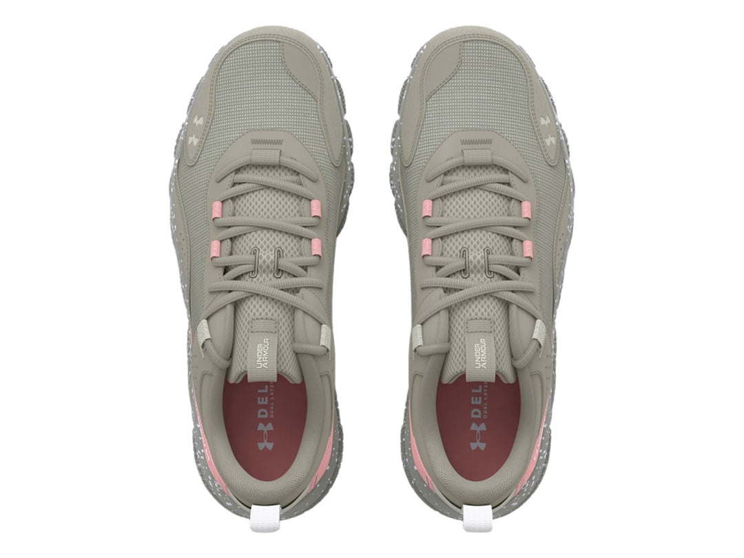 Tenis deportivos Under Armour en color gris con detalles en rosa y suela blanca moteada.