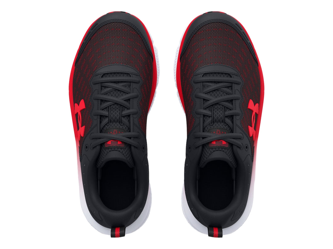 Tenis deportivo Under Armour para niños en color negro con detalles rojos y suela blanca y roja.