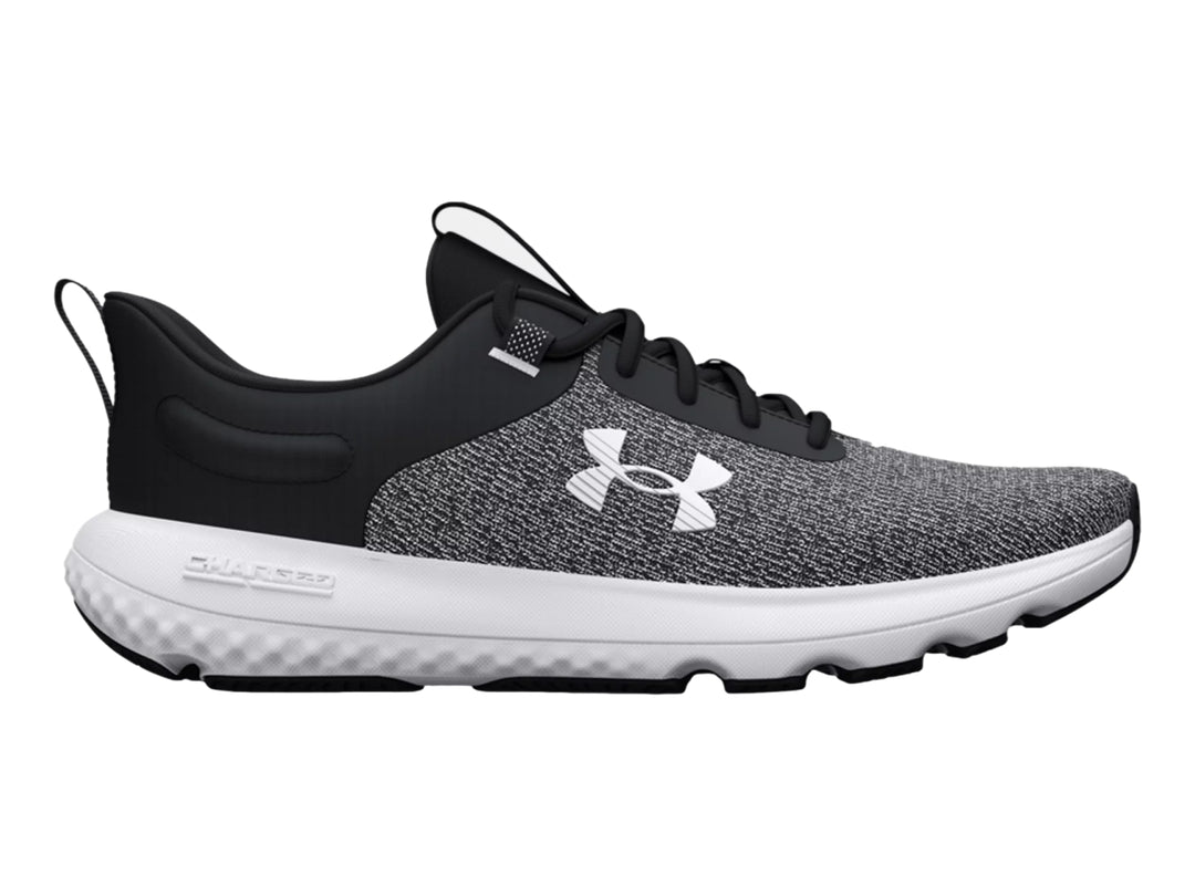 Tenis deportivos Under Armour en color negro y blanco con suela blanca y tejido transpirable.