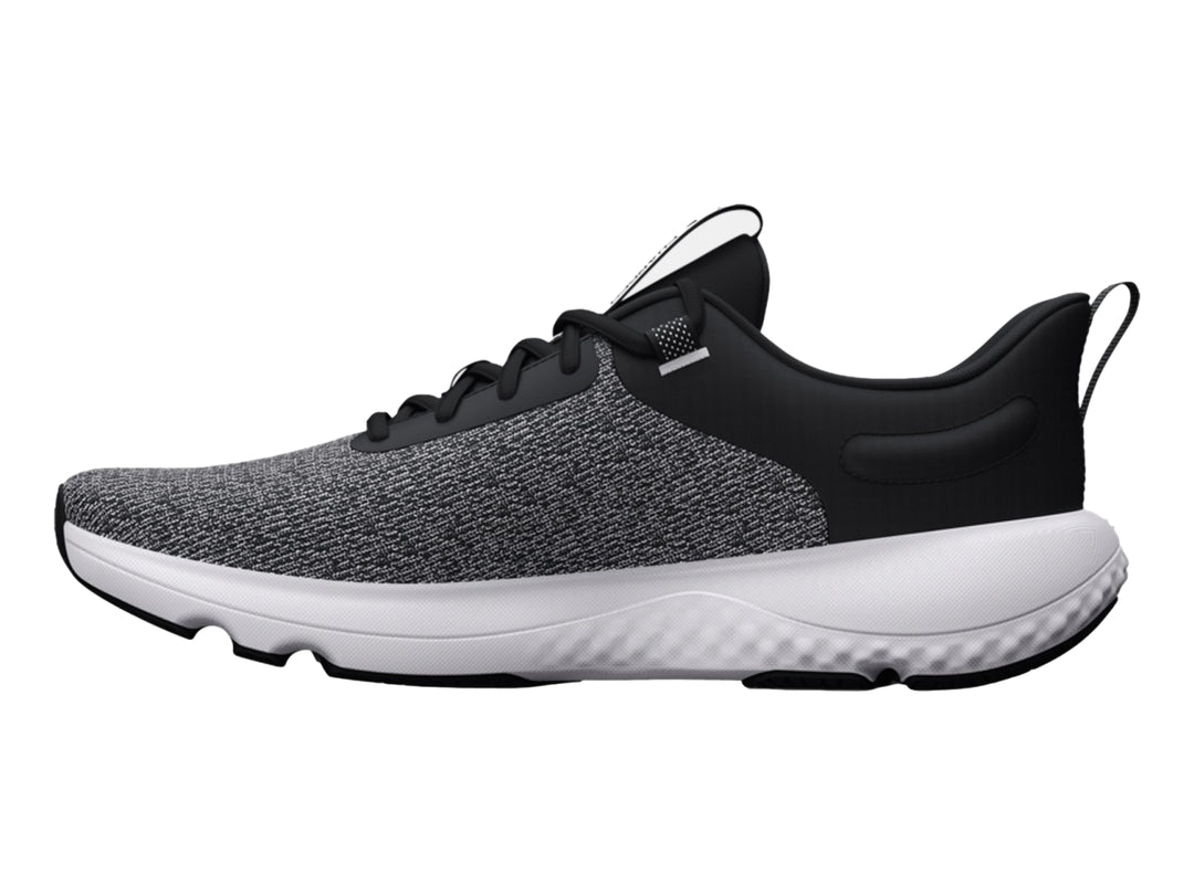 Tenis deportivos Under Armour en color negro y blanco con suela blanca y tejido transpirable.