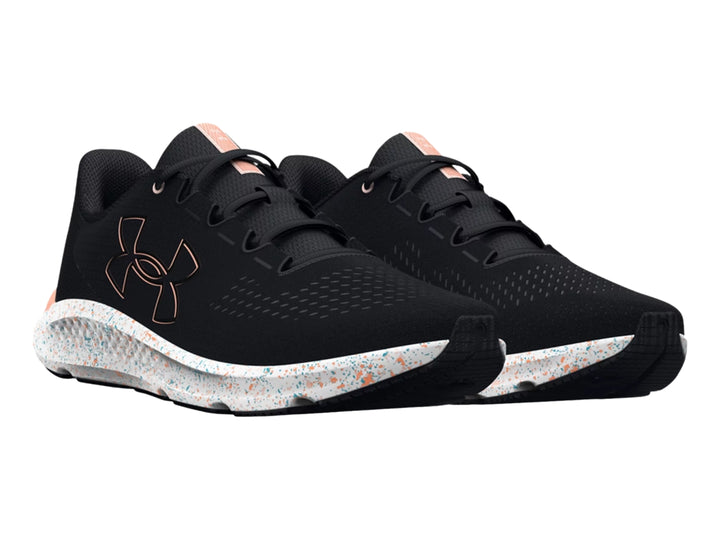 Tenis deportivos Under Armour color negro con suela blanca moteada y detalles en color durazno.
