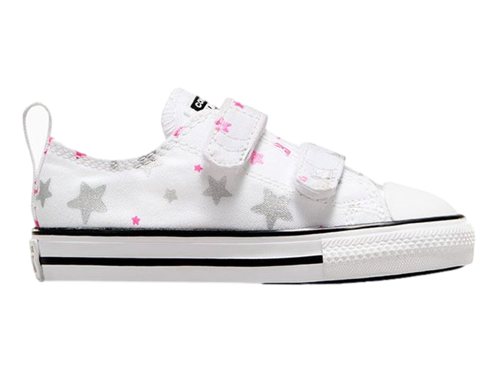 Tenis Converse blancos para niño o niña con estampado de estrellas grises y rosas, cierre de velcro y suela blanca.
