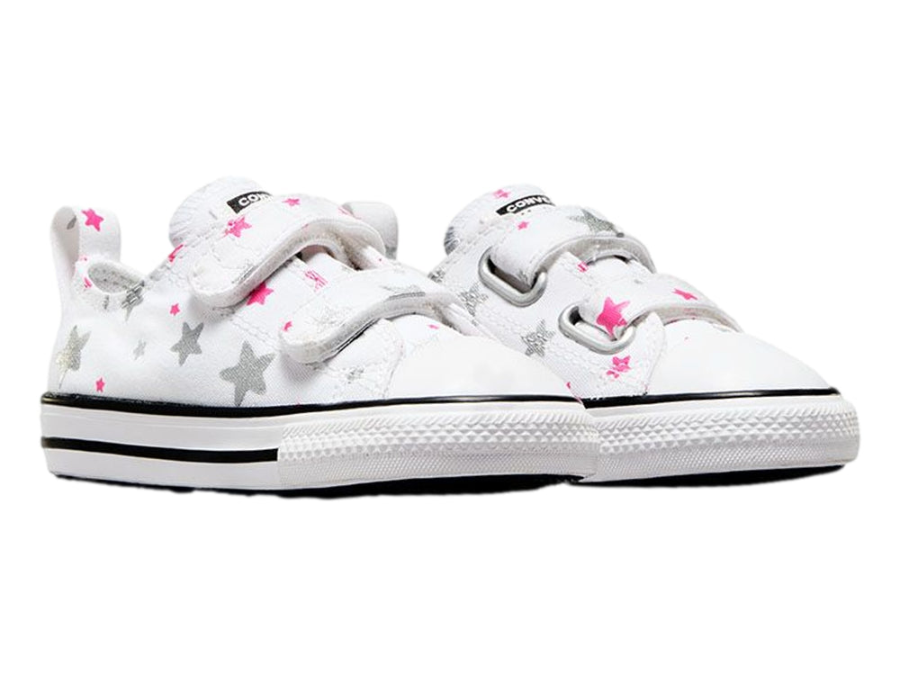 Tenis Converse blancos para niño o niña con estampado de estrellas grises y rosas, cierre de velcro y suela blanca.