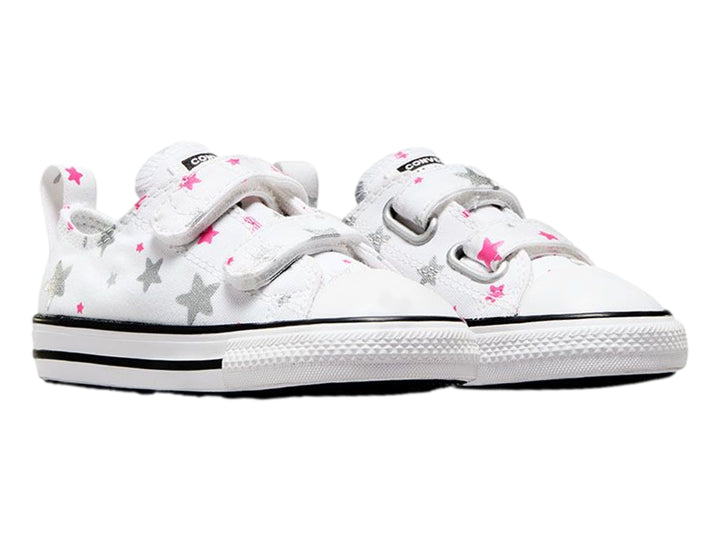 Tenis Converse blancos para niño o niña con estampado de estrellas grises y rosas, cierre de velcro y suela blanca.