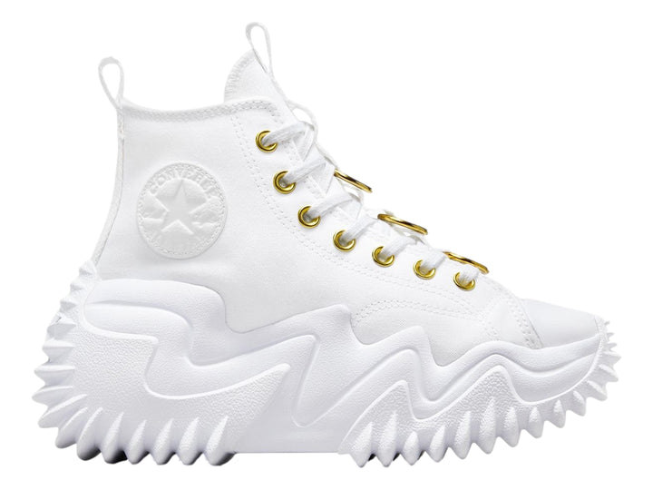 Tenis Converse blancos de bota con suela plataforma ondulada y ojillos dorados.