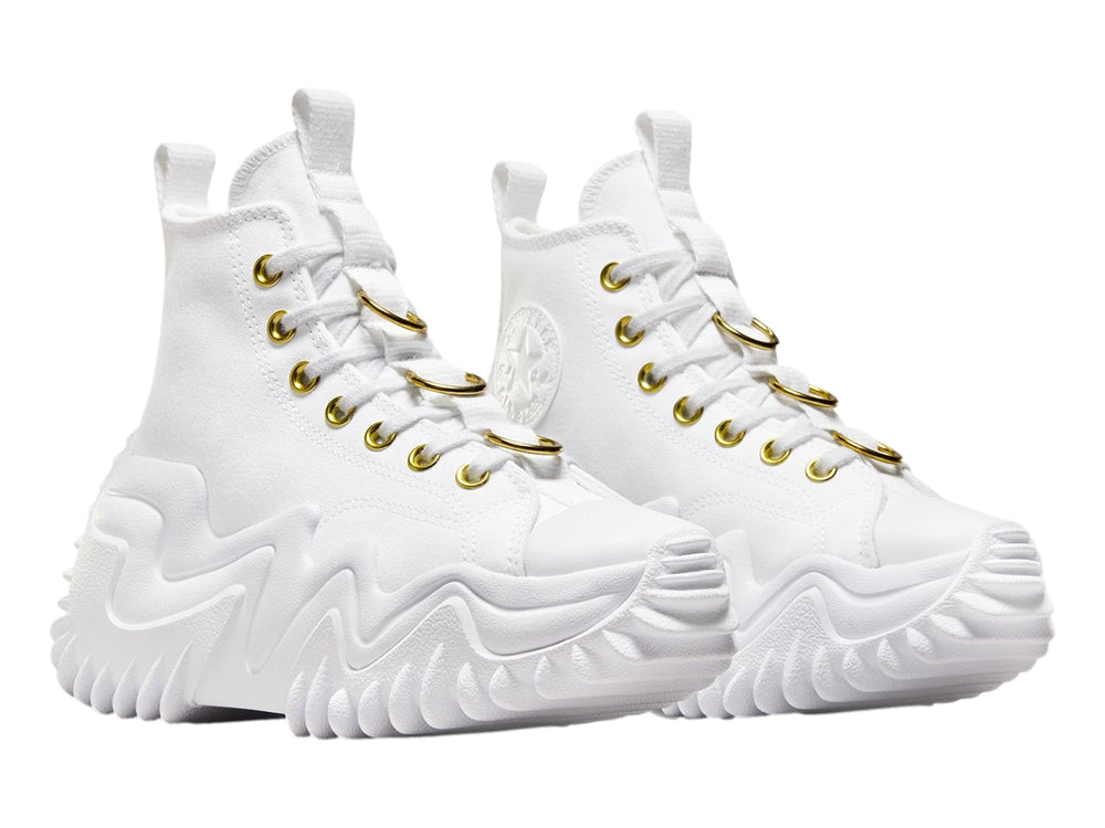 Tenis Converse blancos de bota con suela plataforma ondulada y ojillos dorados.
