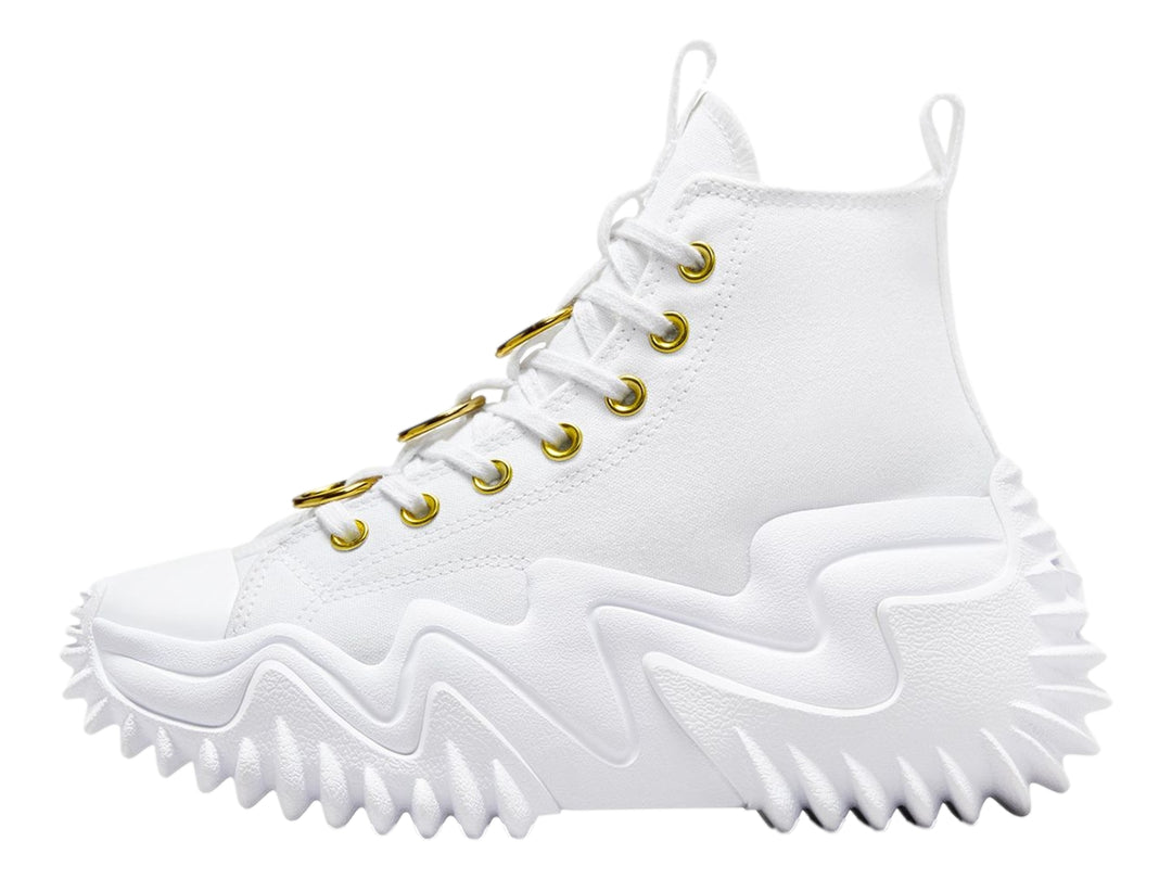 Tenis Converse blancos de bota con suela plataforma ondulada y ojillos dorados.