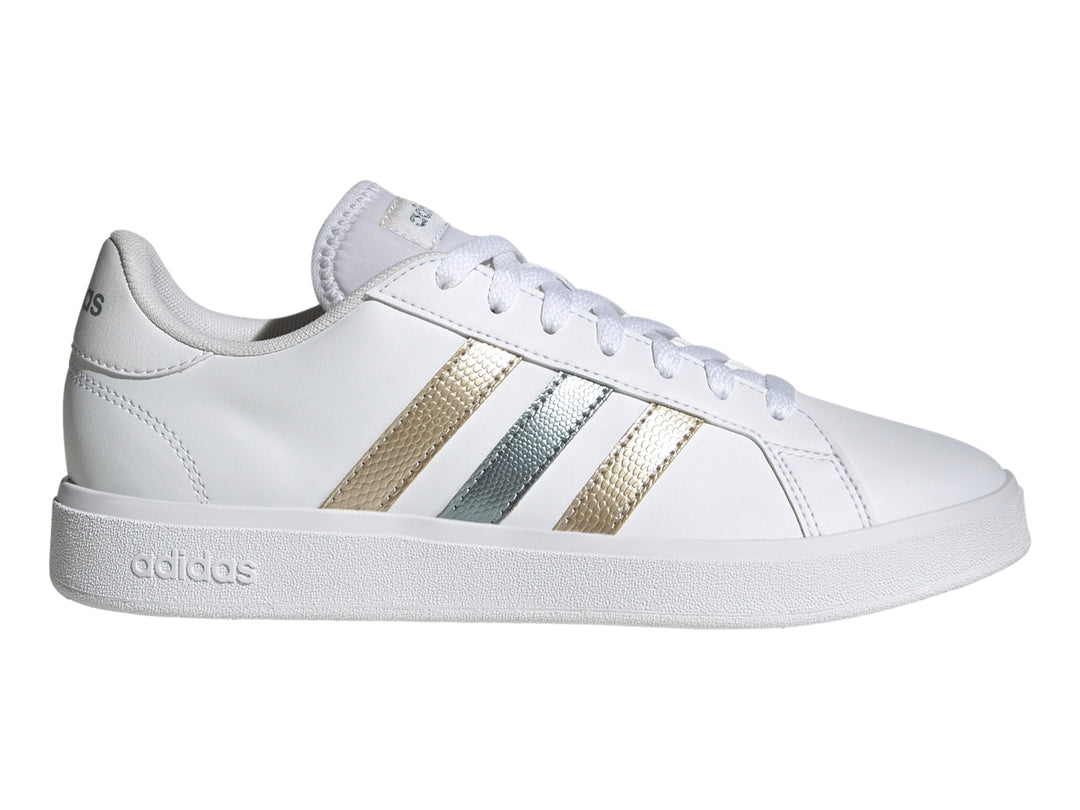 Tenis Adidas blancos con tres franjas metálicas en tonos dorado y plateado y suela blanca.