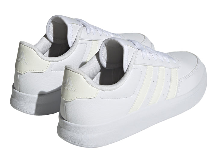Tenis Adidas Breaknet 2.0 en color blanco con tres franjas laterales en tono crema y suela blanca.