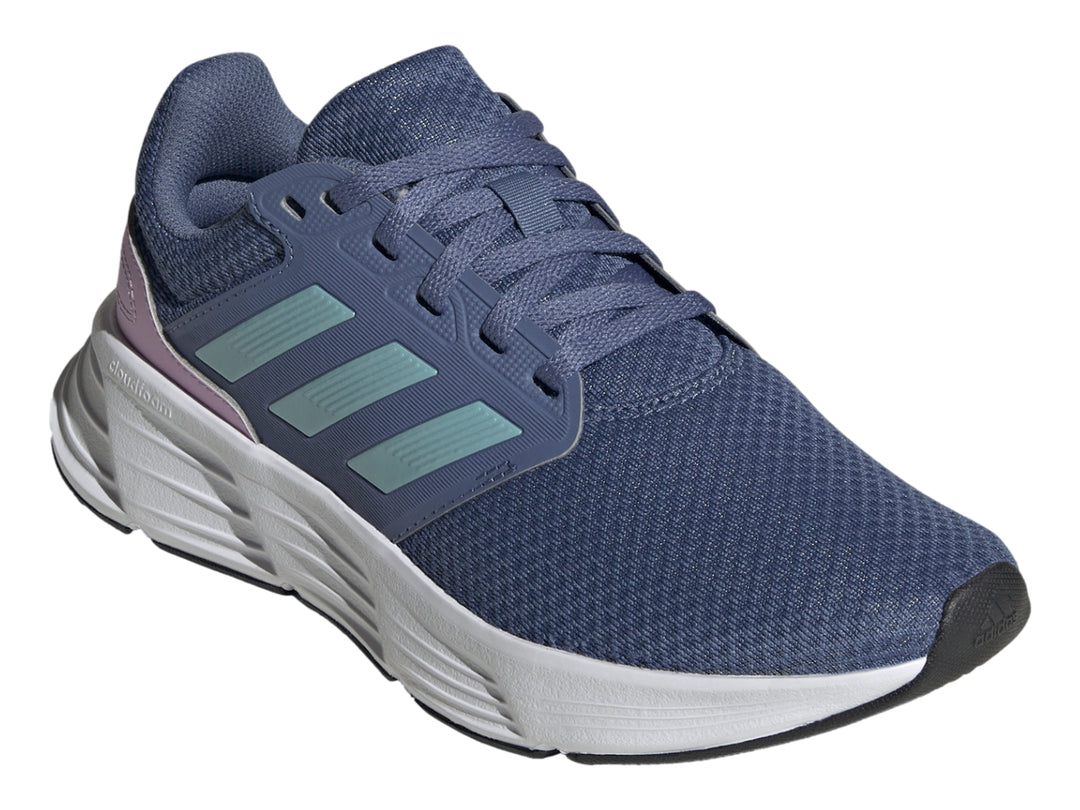 Tenis deportivos Adidas color azul con rayas aqua, detalle lila en el talón y suela blanca.