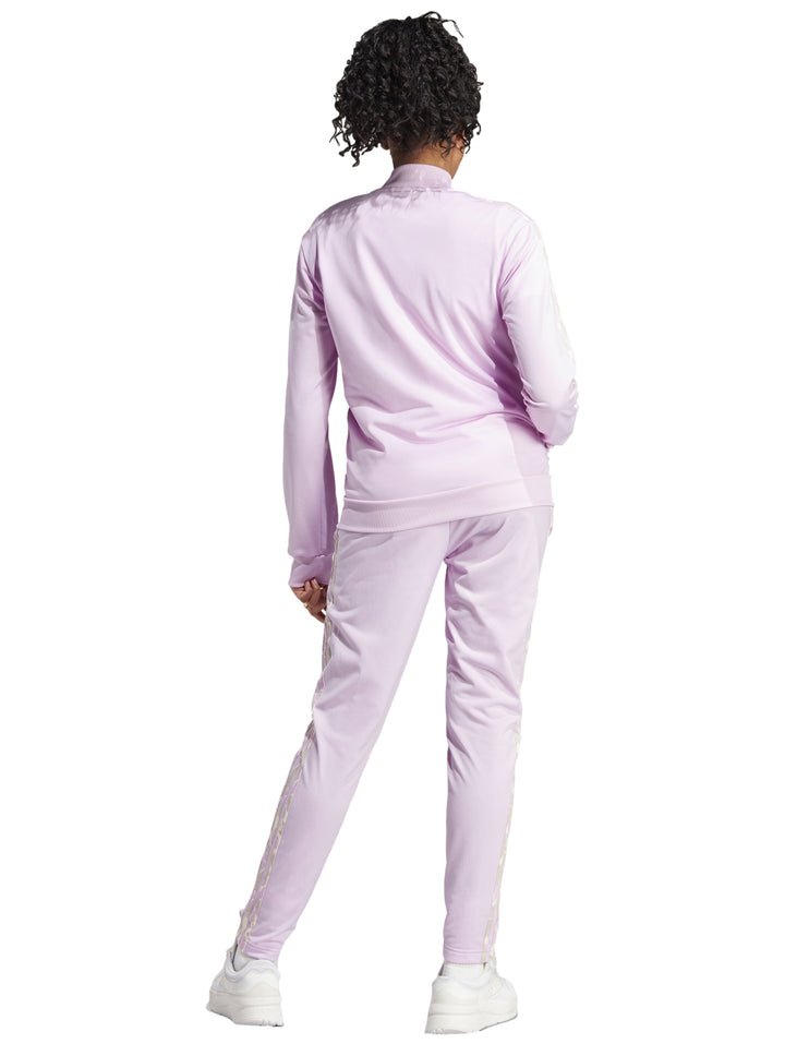 Mujer vistiendo pantalones deportivos Adidas en color lila con rayas laterales multicolores.
