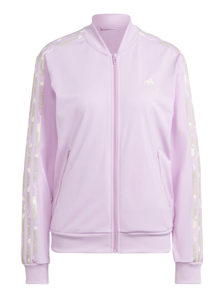 Mujer vistiendo pantalones deportivos Adidas en color lila con rayas laterales multicolores.
