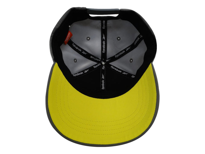 Gorra deportiva Reebok de color gris con logotipo amarillo bordado en el frente.