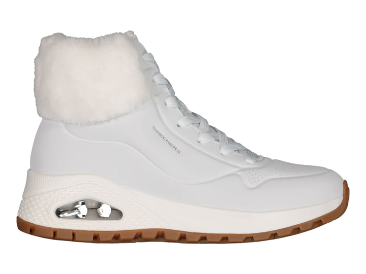 Botín deportivo Skechers blanco con forro interior de peluche blanco y suela color café.
