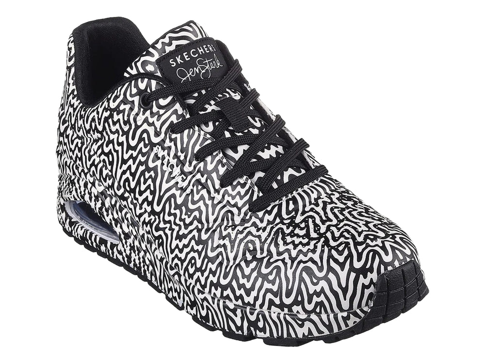 Tenis deportivos Skechers con estampado ondulado en blanco y negro y suela con amortiguación visible.