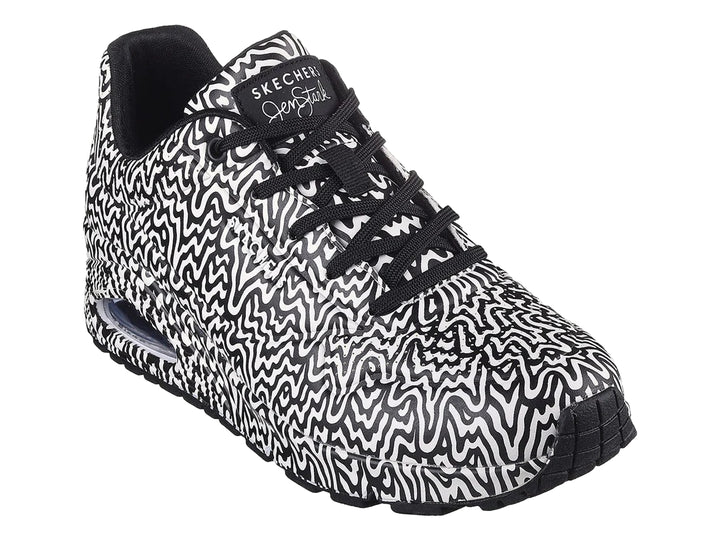 Tenis deportivos Skechers con estampado ondulado en blanco y negro y suela con amortiguación visible.