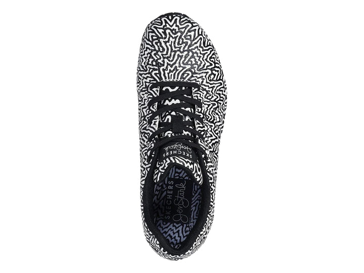 Tenis deportivos Skechers con estampado ondulado en blanco y negro y suela con amortiguación visible.