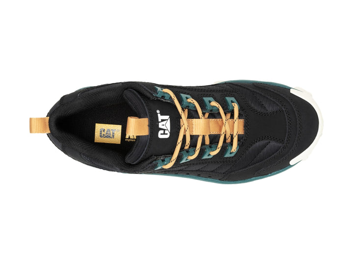 Tenis Caterpillar negros con suela gruesa color crema y detalles en verde oscuro.