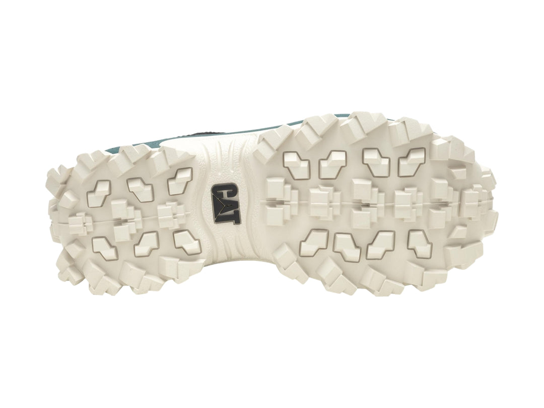 Tenis Caterpillar negros con suela gruesa color crema y detalles en verde oscuro.