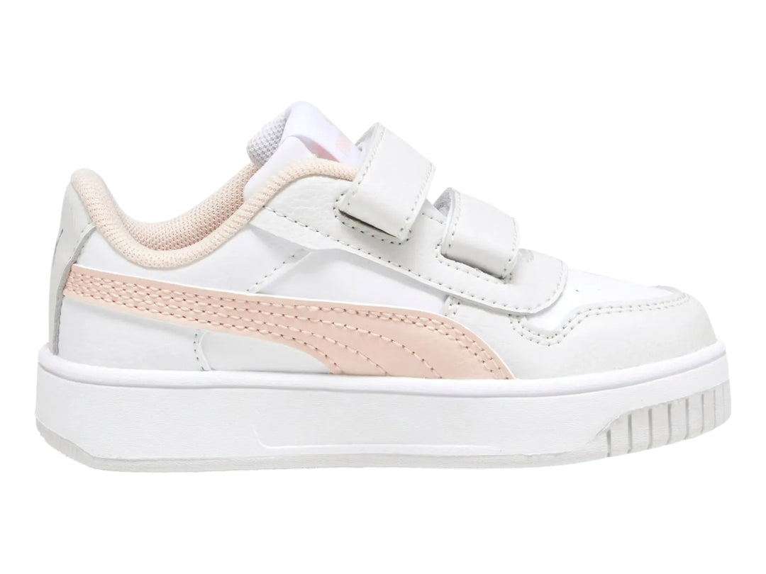 Tenis PUMA blancos para niña con franja rosa y cierre de velcro.