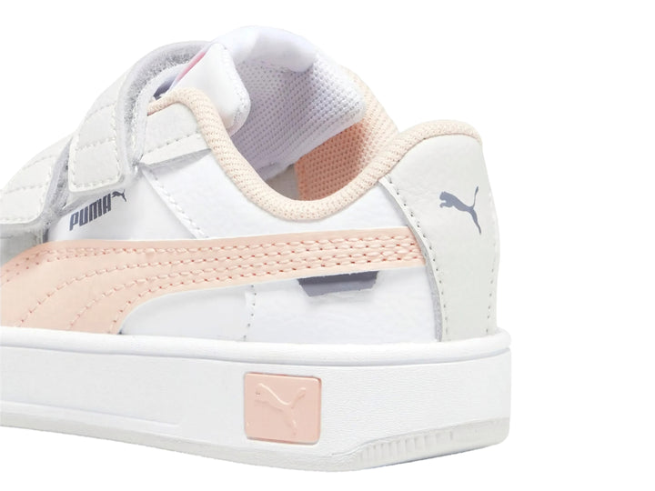Tenis PUMA blancos para niña con franja rosa y cierre de velcro.