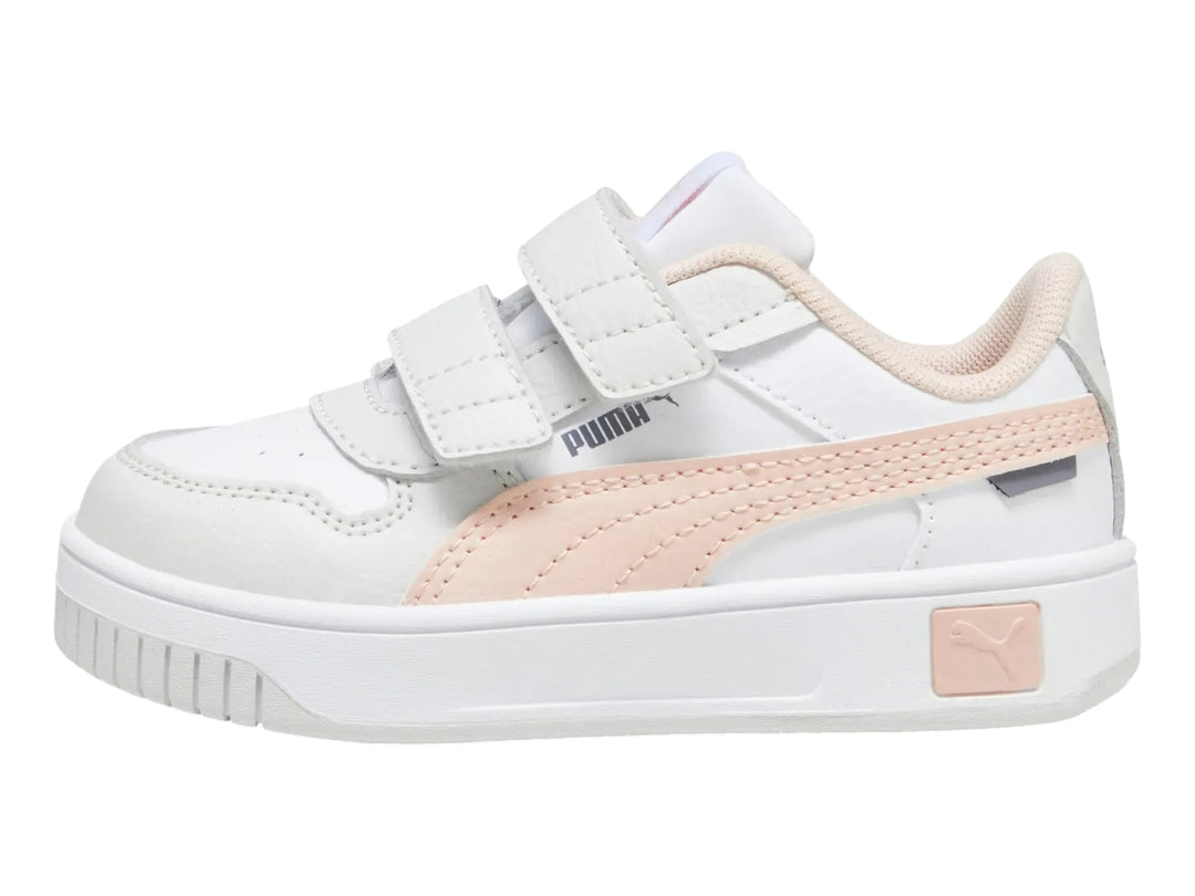 Tenis PUMA blancos para niña con franja rosa y cierre de velcro.