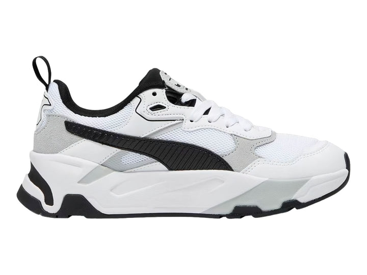 Tenis PUMA Trinity blancos con detalles en negro y gris y suela robusta.