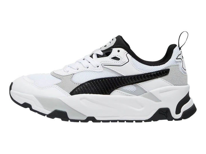 Tenis PUMA Trinity blancos con detalles en negro y gris y suela robusta.