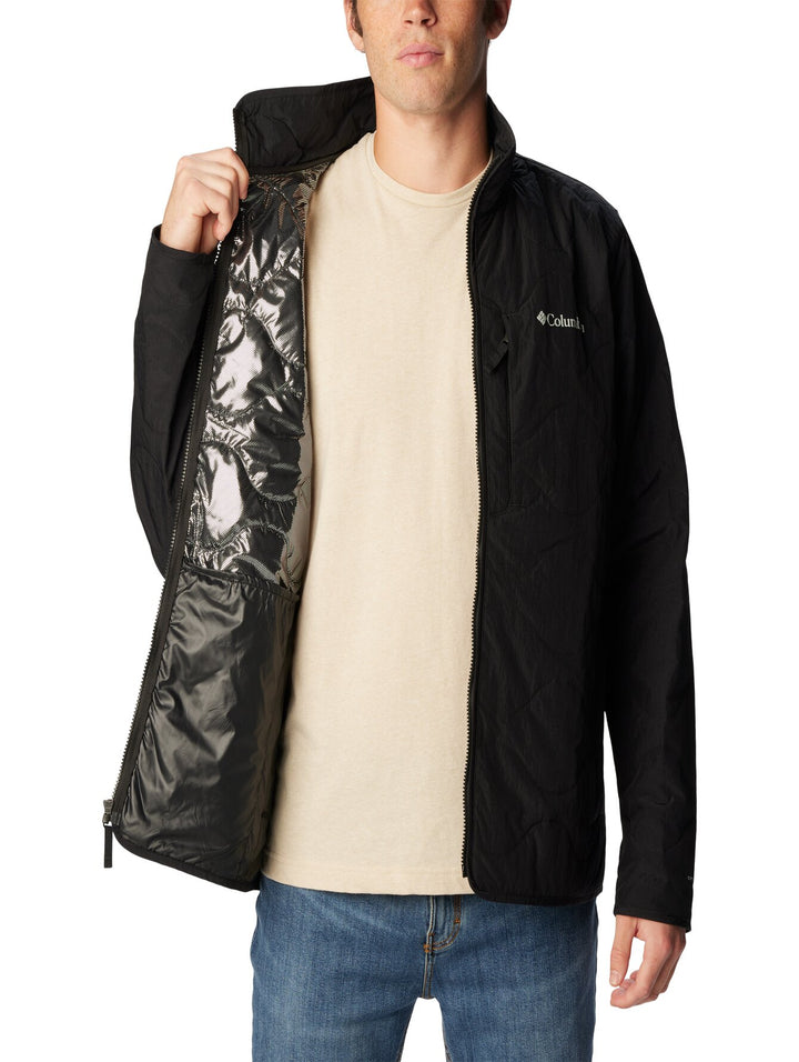 Hombre vistiendo una chaqueta Columbia de color negro con cierre frontal y cuello alto.