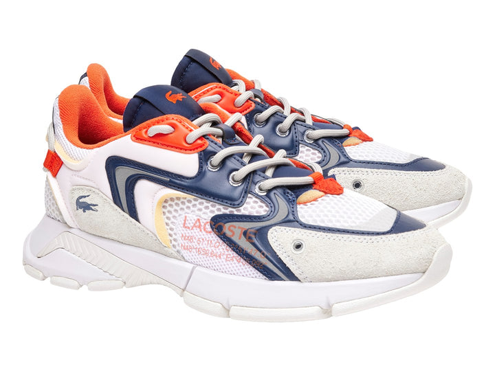 Tenis deportivos Lacoste blancos con detalles en azul marino y naranja y suela blanca gruesa.