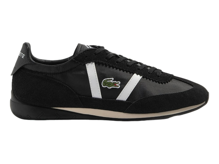 Tenis deportivos Lacoste de color negro con franjas laterales blancas y suela negra.
