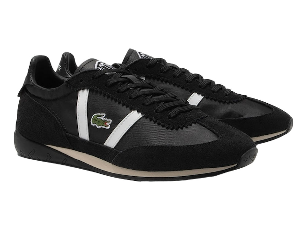 Tenis deportivos Lacoste de color negro con franjas laterales blancas y suela negra.