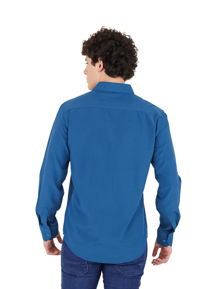 Hombre vistiendo una camisa de manga larga color azul petróleo.