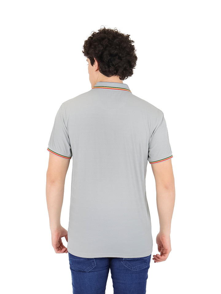 Hombre vistiendo playera polo color gris con detalles de rayas coloridas en cuello y mangas.