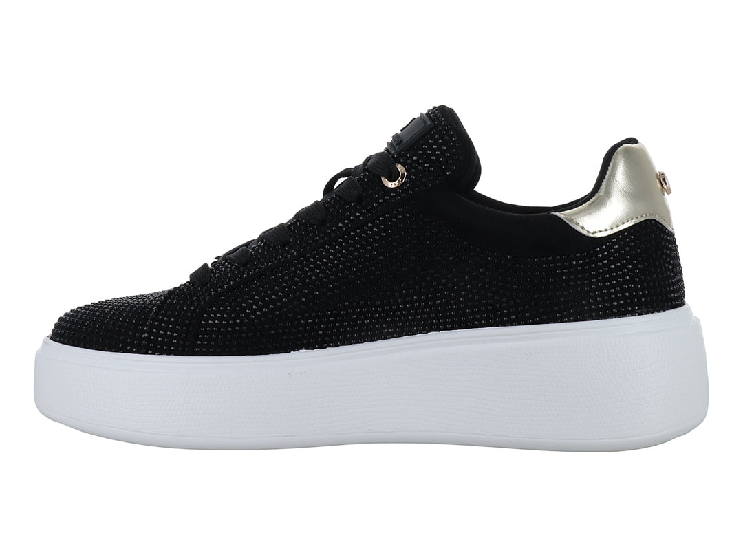 Tenis negros con detalles brillantes, suela blanca de plataforma y detalle dorado en el talón.