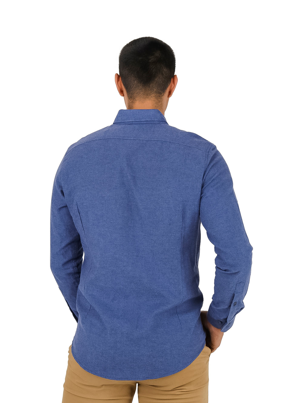 Hombre vistiendo una camisa azul de manga larga estilo mezclilla y pantalones color beige.