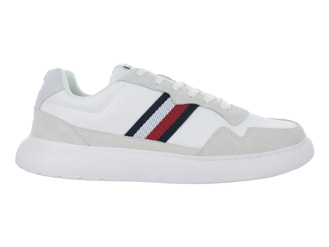 Tenis blancos de cuero con detalles en gris y franjas laterales en rojo, azul y blanco.