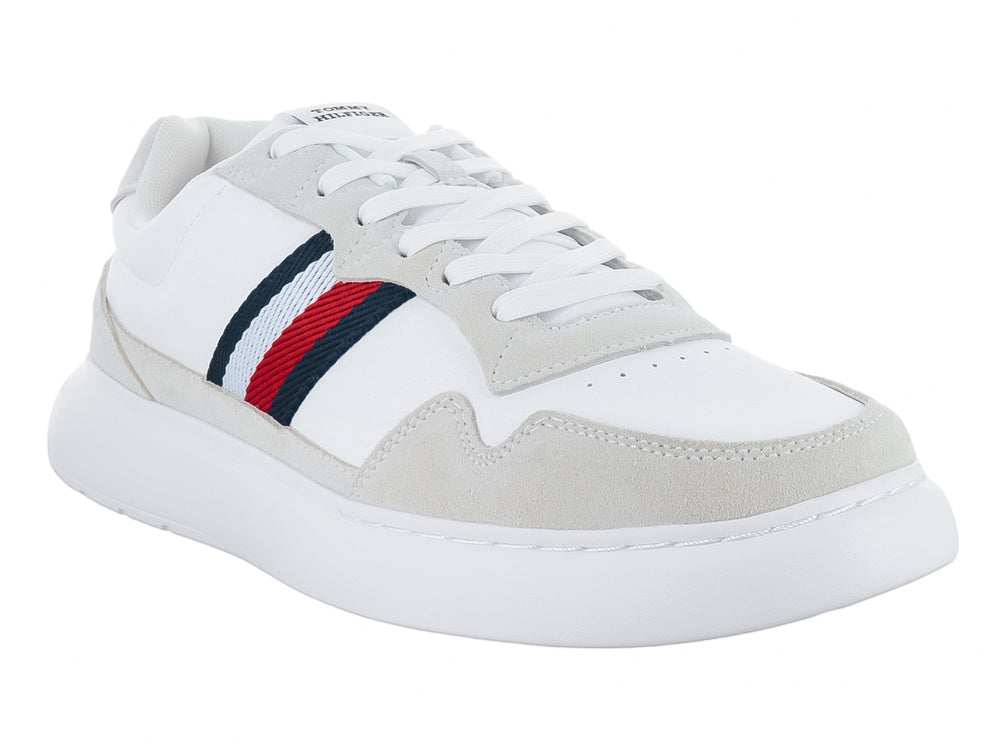 Tenis blancos de cuero con detalles en gris y franjas laterales en rojo, azul y blanco.