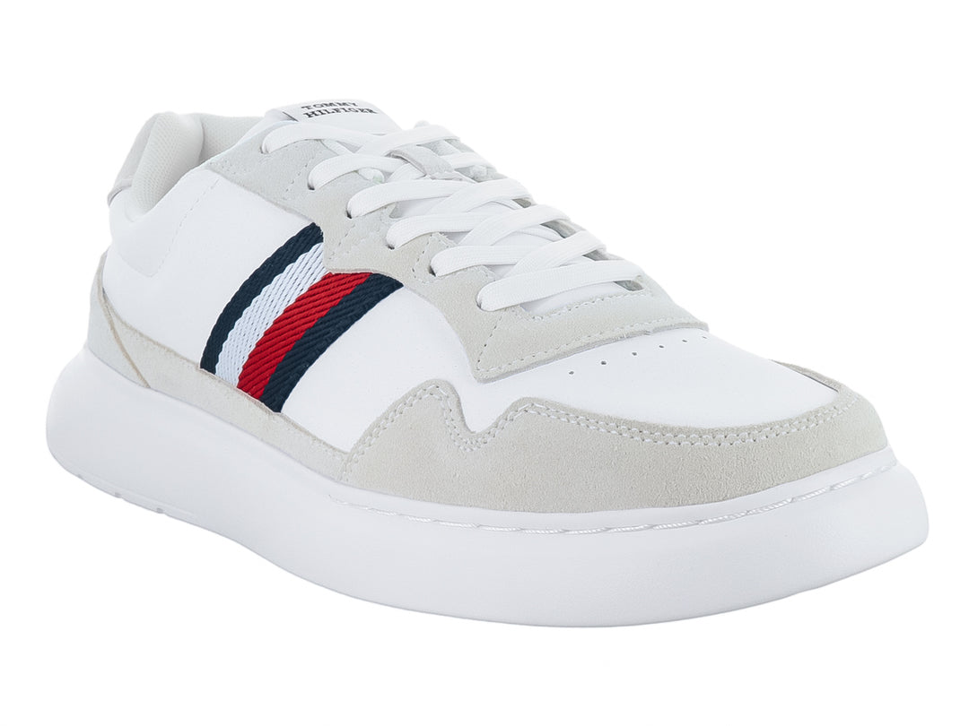 Tenis blancos de cuero con detalles en gris y franjas laterales en rojo, azul y blanco.