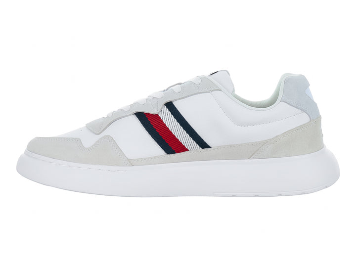 Tenis blancos de cuero con detalles en gris y franjas laterales en rojo, azul y blanco.