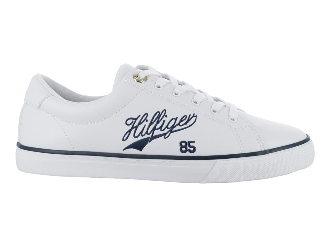 Tenis blancos Tommy Hilfiger con detalles en azul marino y texto Hilfiger 85 en el lateral.