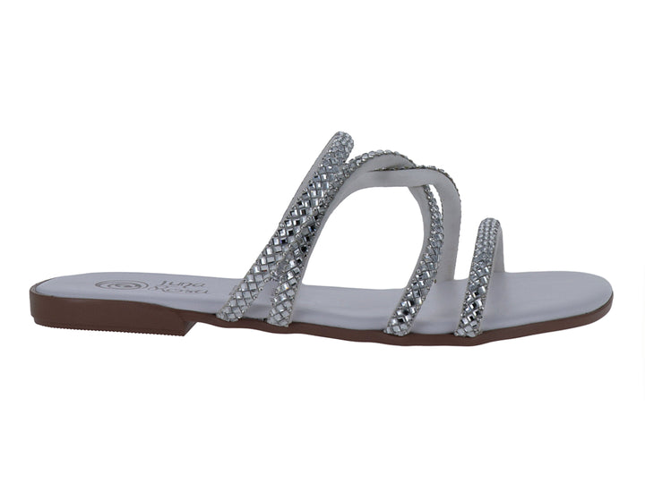 Sandalia blanca y plata con tiras brillantes y suela plana.